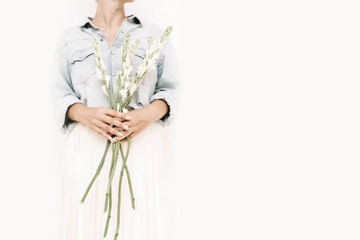 woman holding large white floral stems of a bouquet